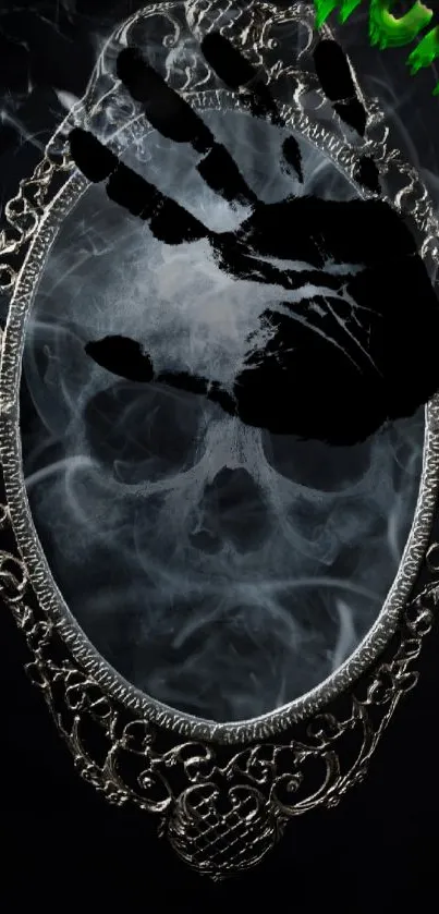 Intricate mirror with smoky skull and a dark handprint on a black background.