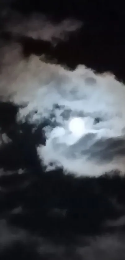 Mysterious moon behind dark clouds at night.