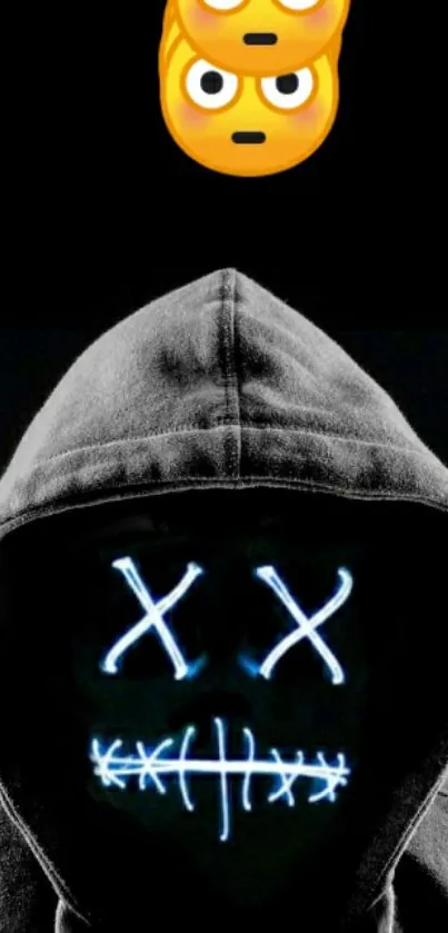 Hooded figure with neon mask and emoji on black background.