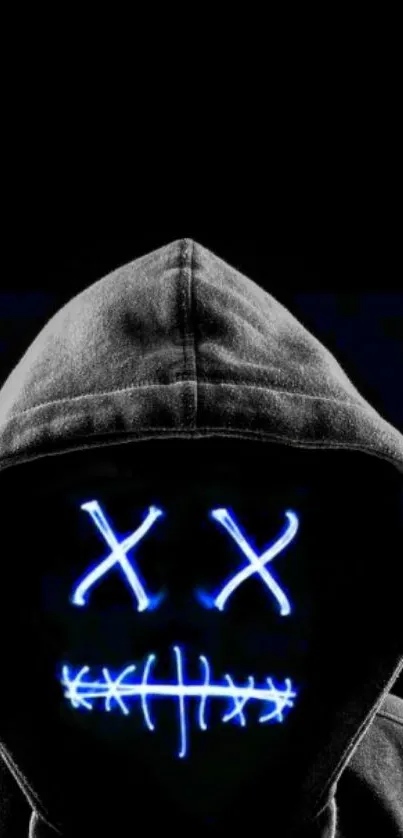 Hooded figure with blue neon mask on dark background.