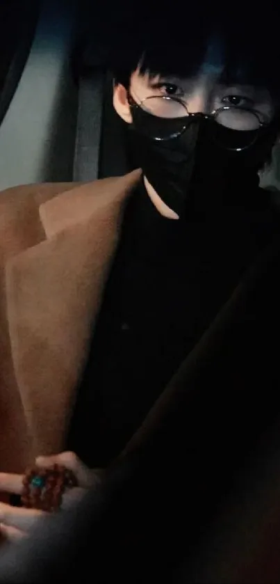 Mysterious figure in a brown coat with a mask and glasses in low light.