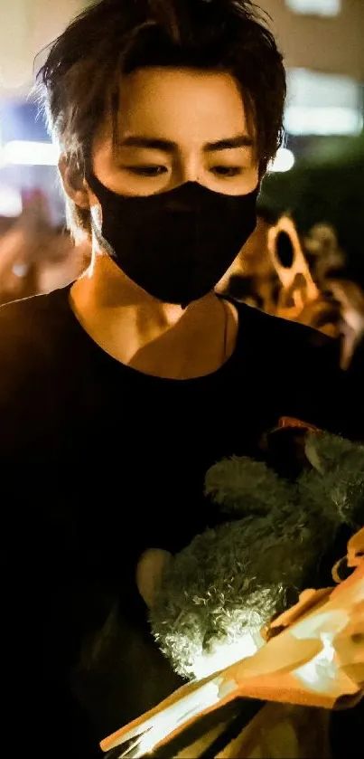 Masked individual in dim lighting holding flowers at night.