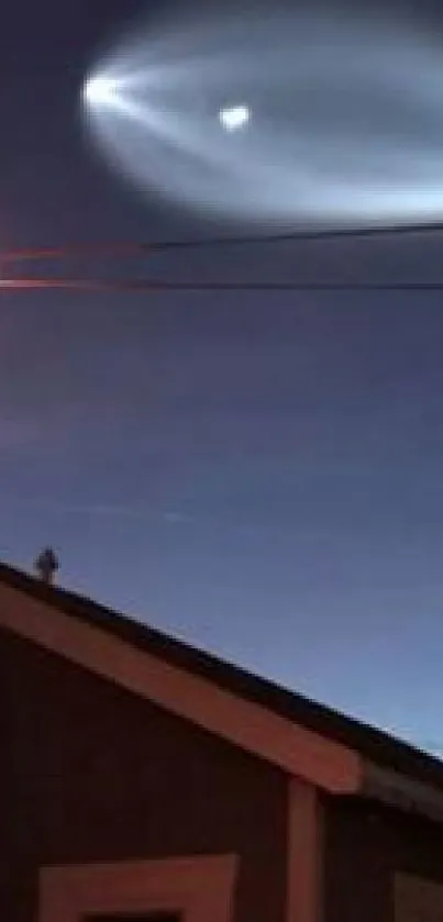 Mysterious night sky light above a house roof.