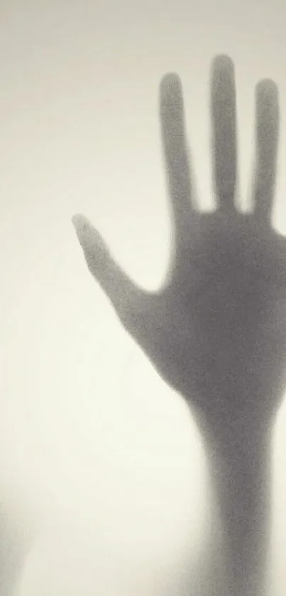 Shadow of a hand silhouetted on a grey background for mobile wallpaper.