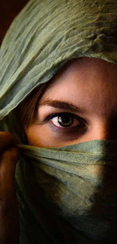 Veiled woman with captivating eyes in an olive green wrap.