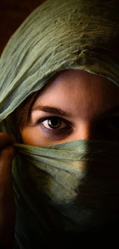 Close-up of veiled eyes in olive green scarf.