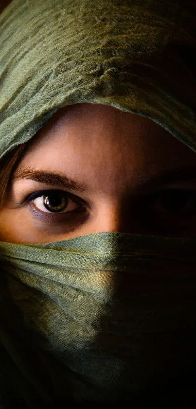 Veiled woman's portrait with intense eyes and olive green fabric.