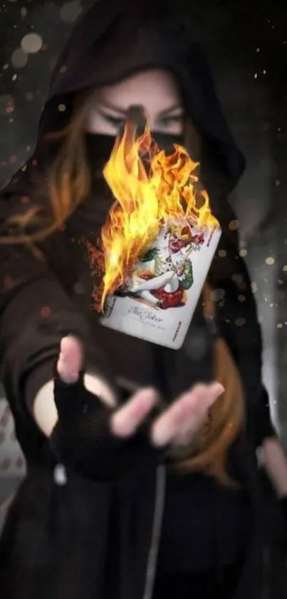 Mysterious figure holding a flaming card with dark background.