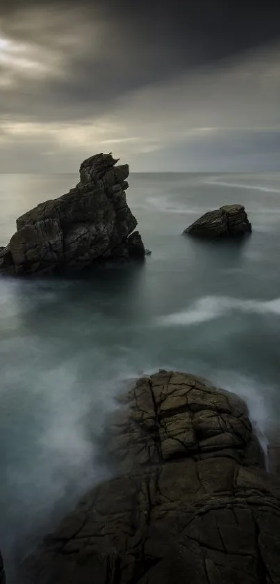 Mystic seaside rock with calm waters and dramatic sky wallpaper.