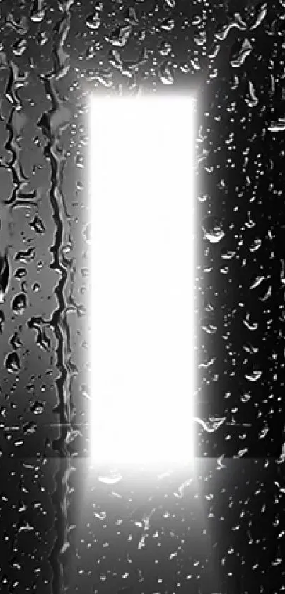 A bright light shining through raindrops on a dark window.