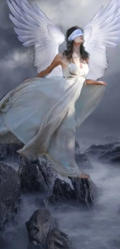 Mystical angel with wings on a cloudy sky background and rocky landscape.