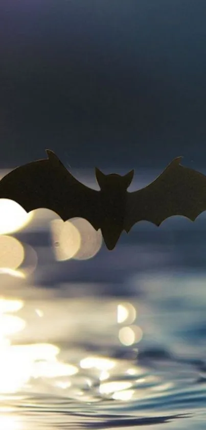 Silhouette of a bat over reflective water with a dark sky.