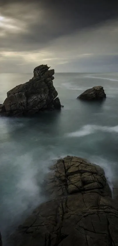 Mystical view of ocean rocks under a cloudy sky.