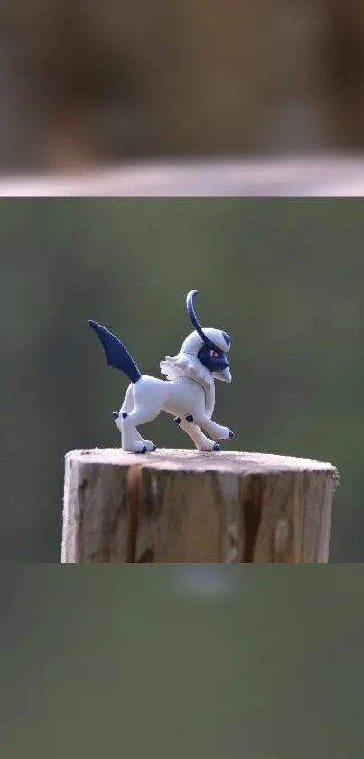 Fantasy creature sculpture on wooden stump in nature background.