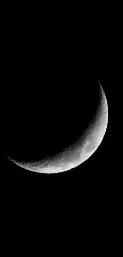 Crescent moon against a dark sky, perfect for minimalist wallpaper.