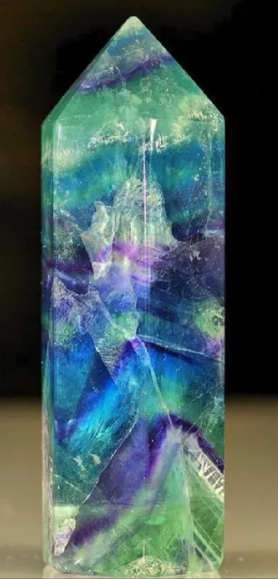 Mystical crystal with vibrant blue and green hues on a black background.