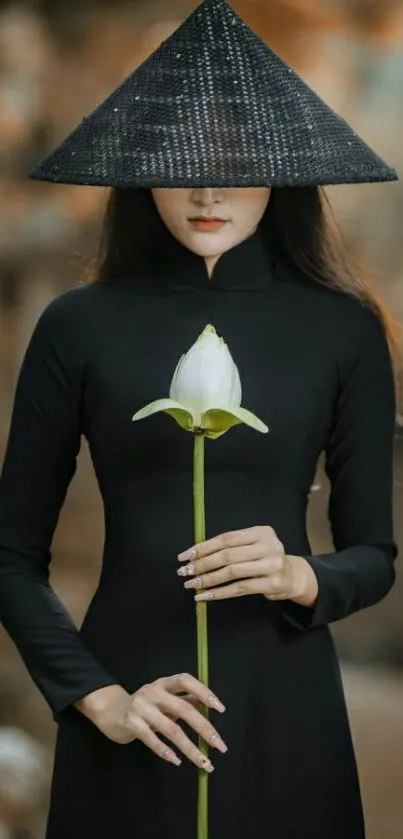 Asian woman in black dress holding lotus flower with hat.