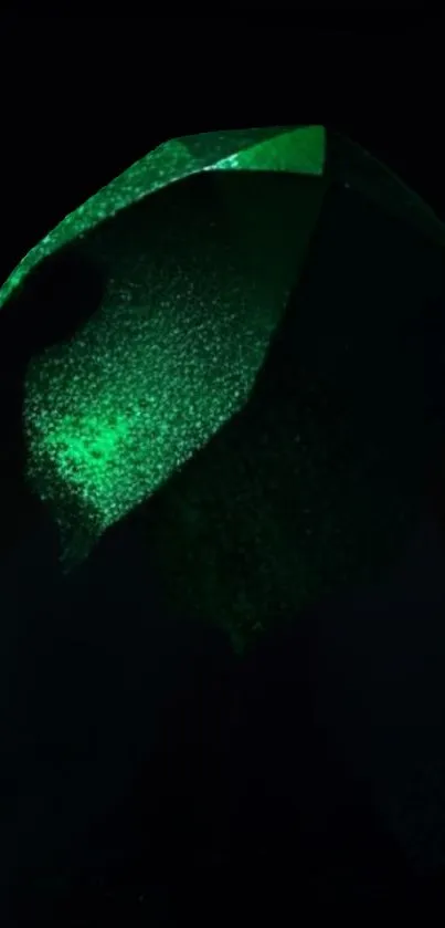 Emerald green glowing stone against dark background wallpaper.