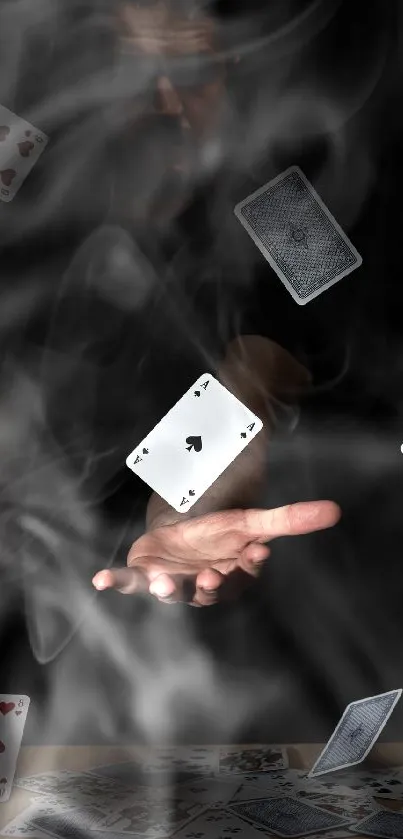 Hand holds floating playing cards in mystical, dark setting.