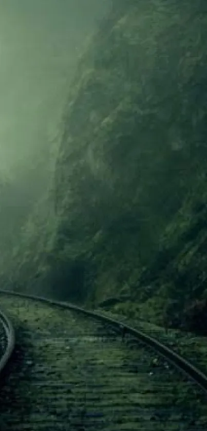 Misty railroad track through a lush green landscape.