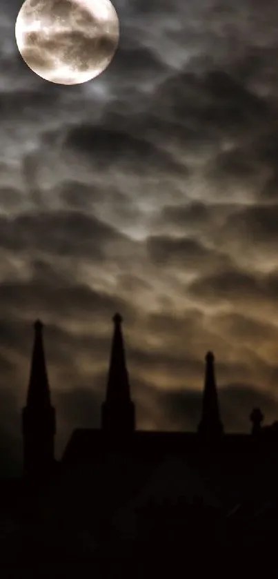 Full moon illuminates a gothic castle silhouette against a cloudy night sky.