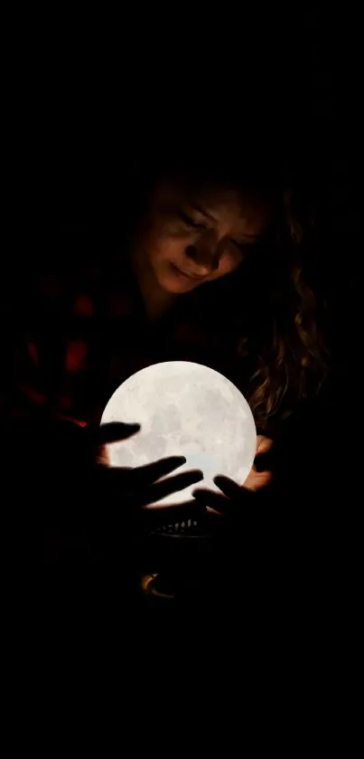 Person holding glowing orb in dark setting.