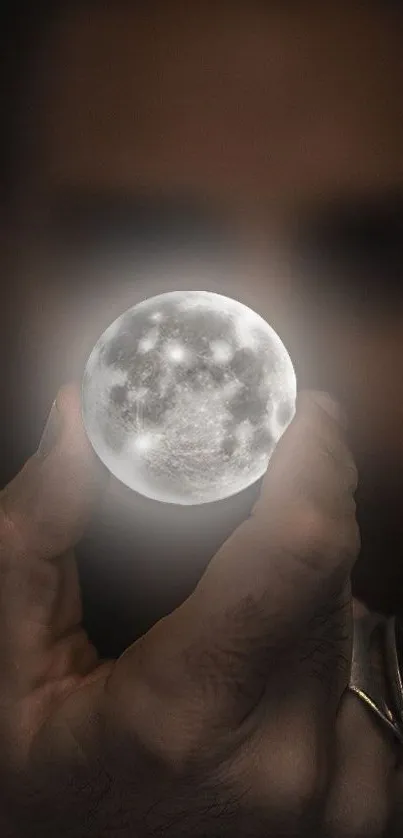 A hand holding a glowing moon orb in darkness, creating a mystical effect.