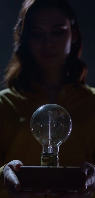 Woman holding a glowing bulb in a dimly lit setting, creating a mystical ambiance.