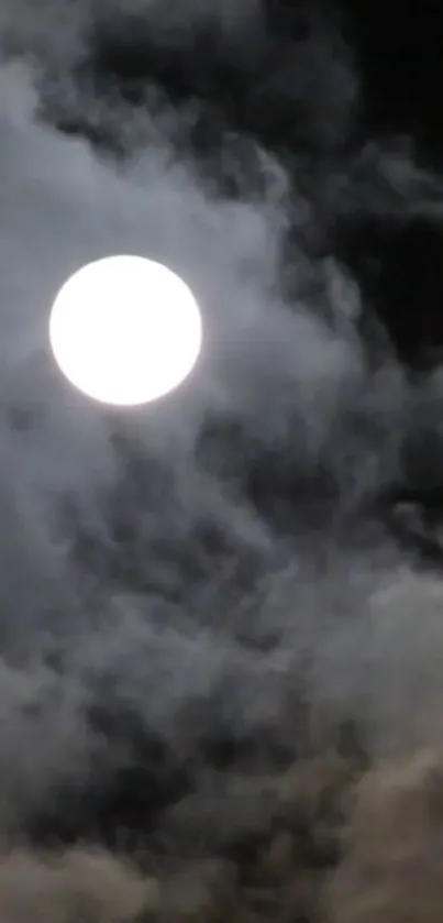 Full moon behind dark, cloudy night sky.