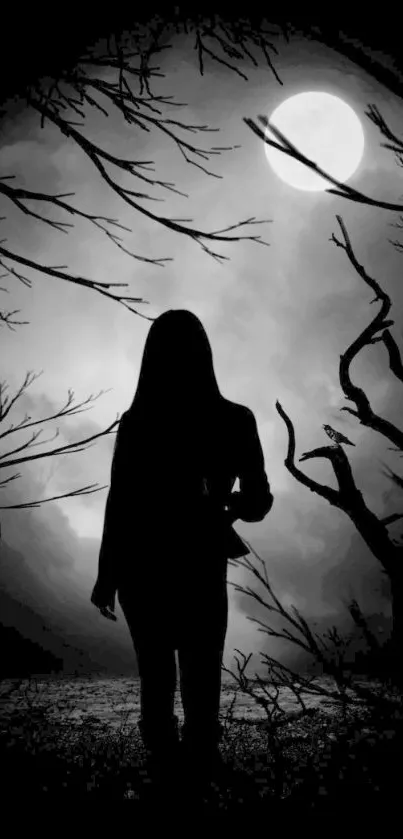 Silhouette of a person against a full moon with bare trees in black and white.