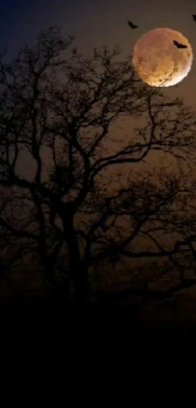 Silhouette of a tree with a full moon and bats in the night sky.