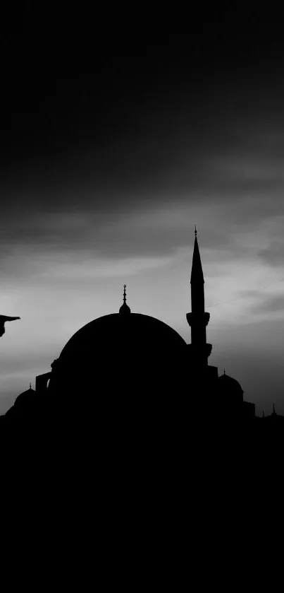 Silhouette of a mosque with a bird flying at dusk in monochrome.