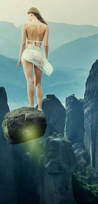 Woman standing on rock amidst mystical mountain landscape.