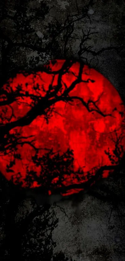 Mystical red moon with dark tree silhouettes on a mobile wallpaper.