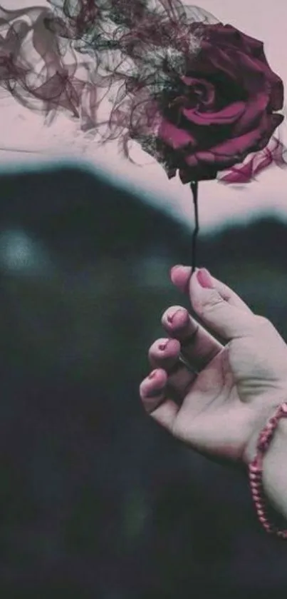 Hand holding a mystical smokey rose on a dark background.