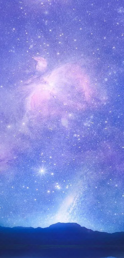 Starry night sky with purple hues over a silhouette of a mountain.