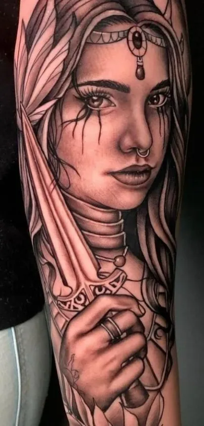 Grayscale tattoo of a mystical warrior woman on arm.