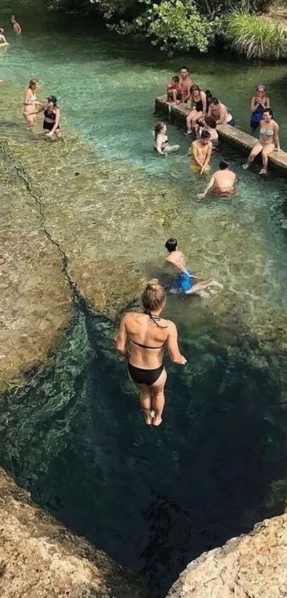 People enjoying a serene natural pool with clear blue water.