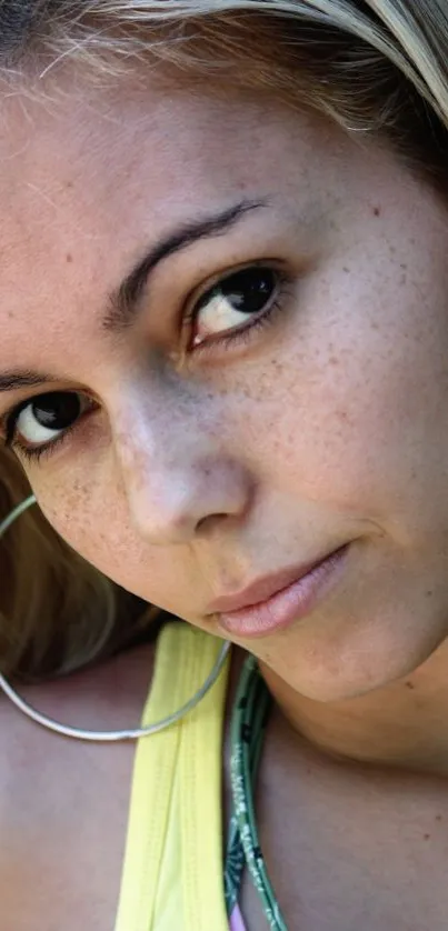 Close-up portrait of a woman with large hoop earrings and subtle makeup.