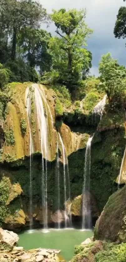 Scenic waterfall surrounded by lush greenery in a tranquil forest setting.