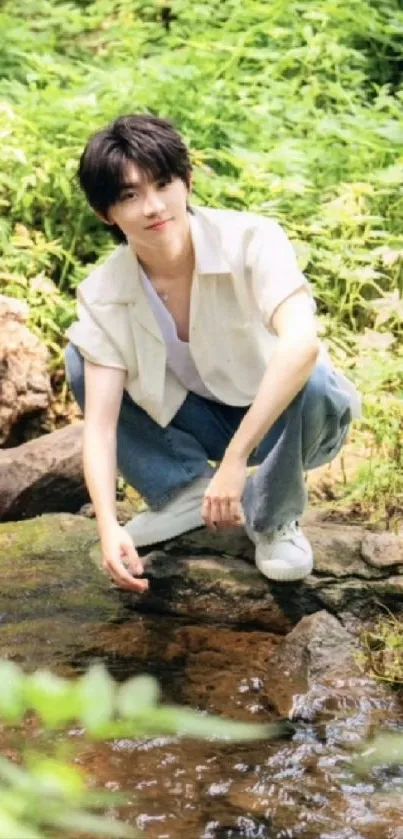 Man by a stream in a green outdoor setting