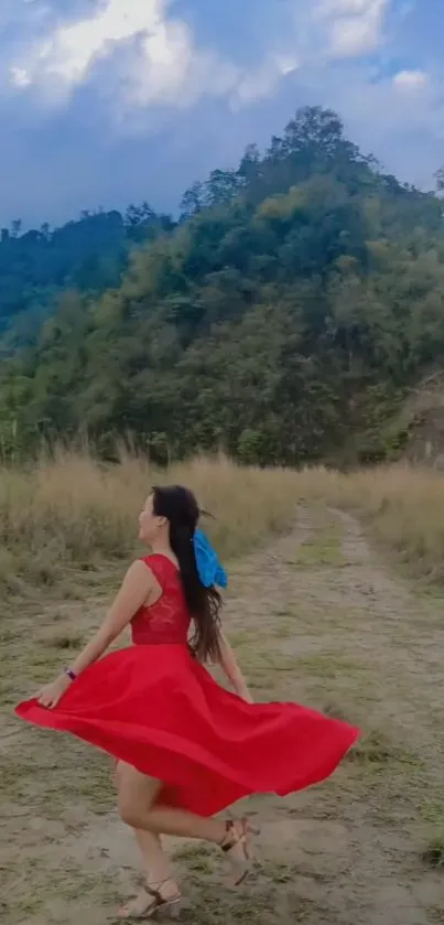 Woman twirling in red dress with hills backdrop.