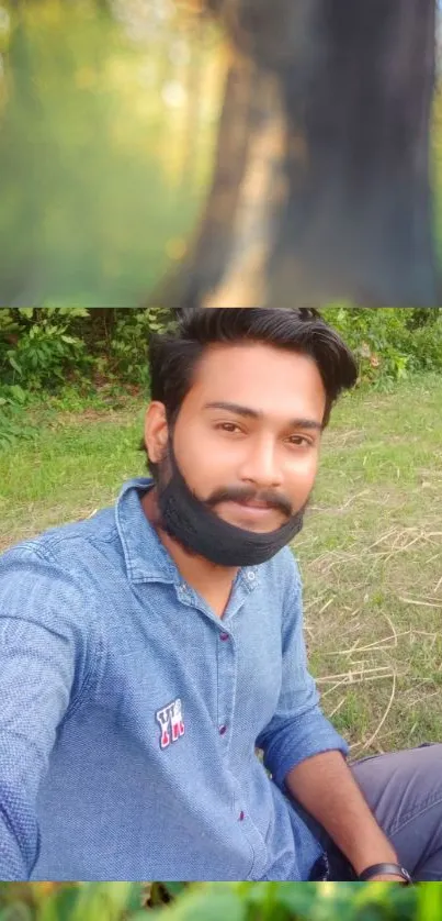 Person in a blue shirt outdoors in a green natural setting.