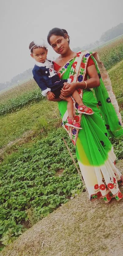 Woman in colorful sari with child in green field.