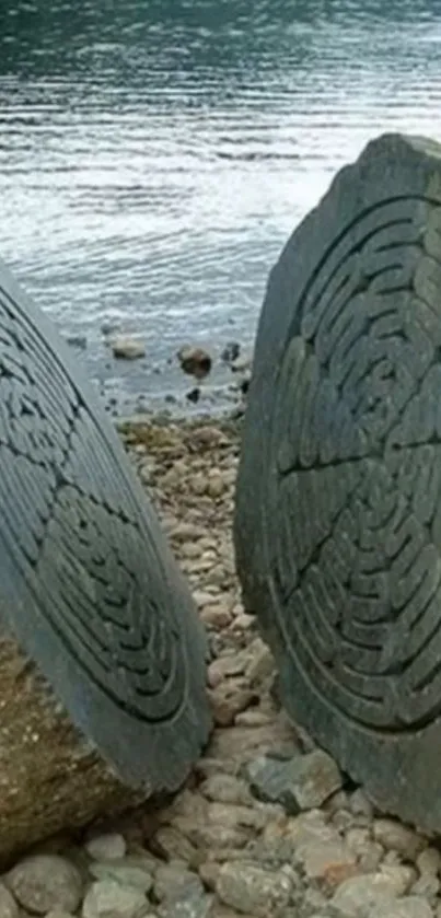 Stone carvings by a tranquil lakeside with rippling water.