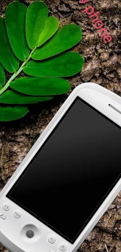 Sleek white phone on textured surface with green leaf.