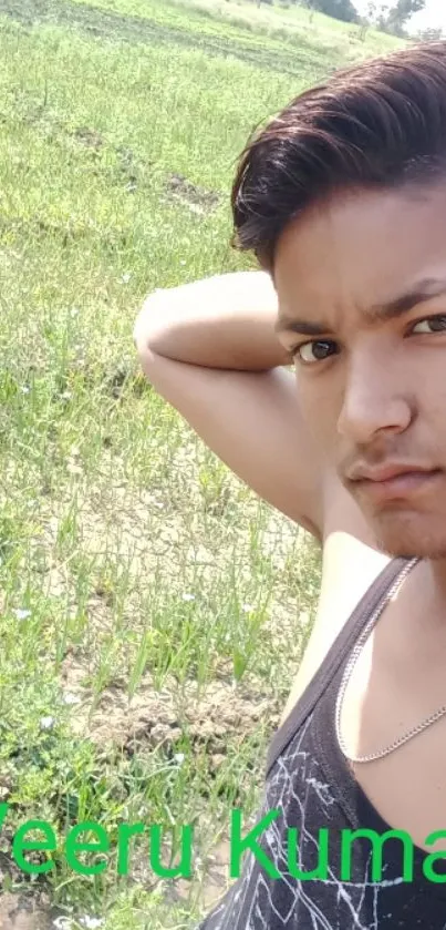 A young person takes a selfie in a sunny green field.