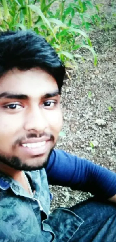 Young individual posing in a garden with greenery and soil background.