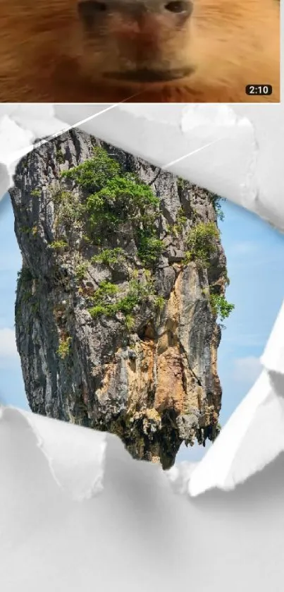 A towering rock formation seen through torn paper against a clear blue sky.