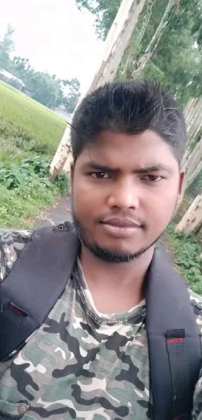 Person in camouflage with green nature backdrop.